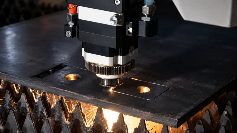 Fiber laser cutting machine cutting sheet metal with sparks for industrial metal fabrication